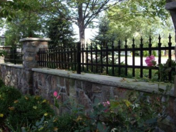 Pagar batu rendah dengan ornamen besi